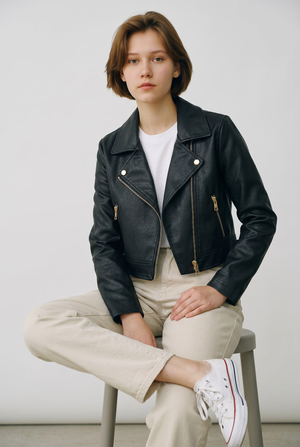 Adan & La black faux leather cropped moto jacket with zipper details and a spread collar.