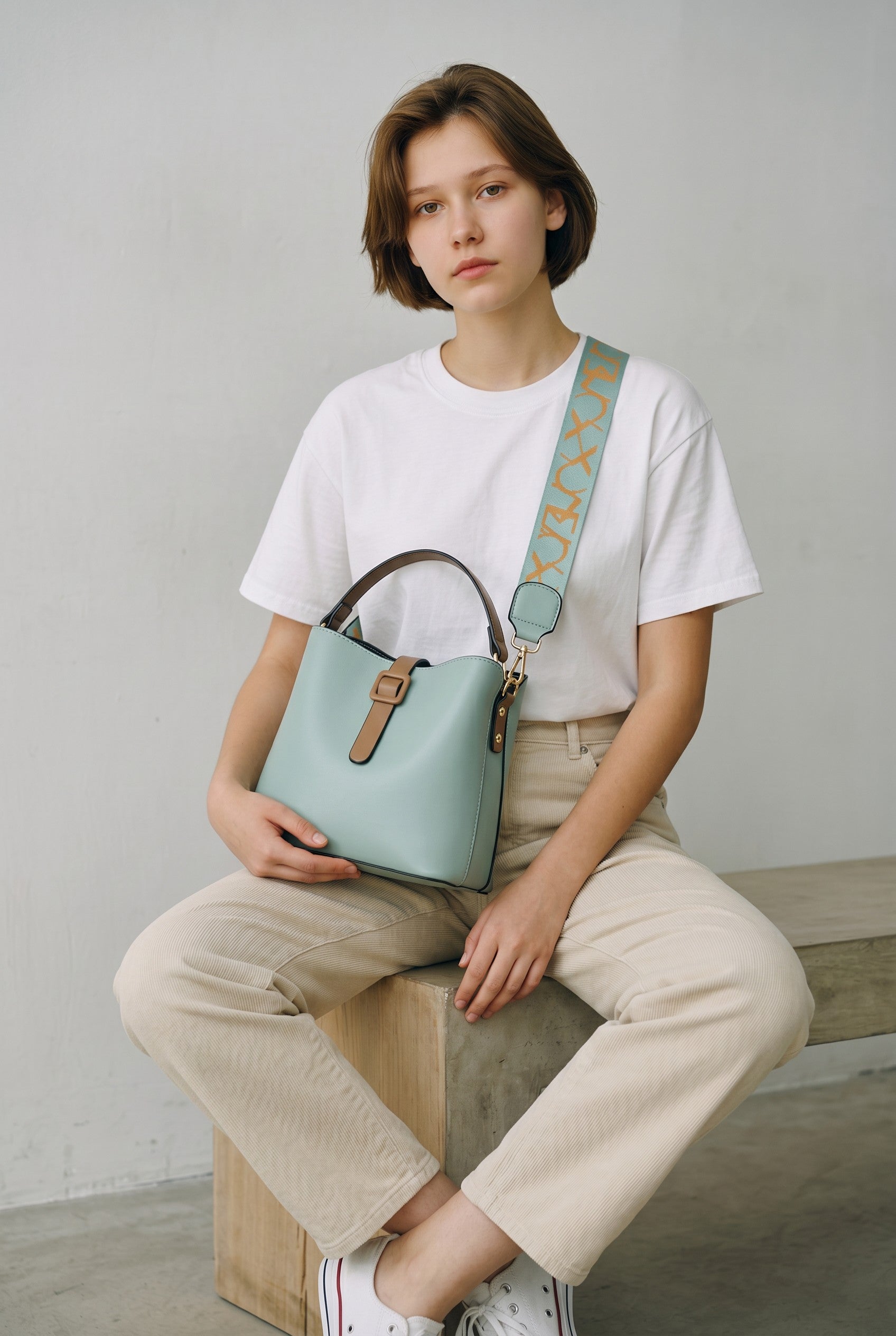 Adan & La women's light blue PU leather bucket bag with tan accents and patterned strap.